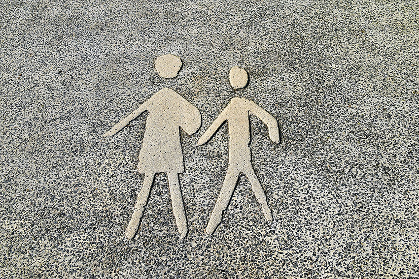 Fond gris moucheté. 2 personnages gravés, sous forme de pictogramme, marchent côte à côte