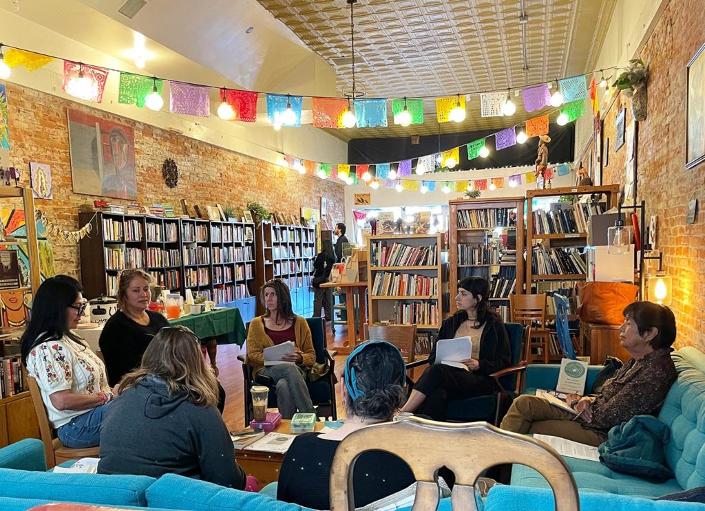 Un groupe est réuni dans une bibliothèque décorée avec des guirlandes lumineuses.
